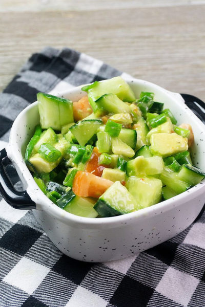 Avocado Cucumber Salad on grey backdrop with black and white plaid napkin