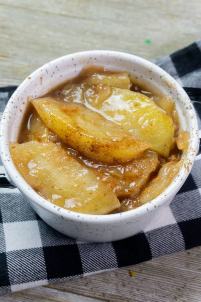Instant Pot Cinnamon Apples on grey wood with black and white plaid napkin.