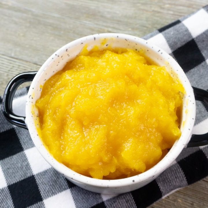 Instant Pot Pumpkin Puree in a white bowl with plaid napkin