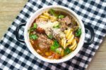 Instant Pot Beef Parmesan Soup with plaid napkin on gray wood