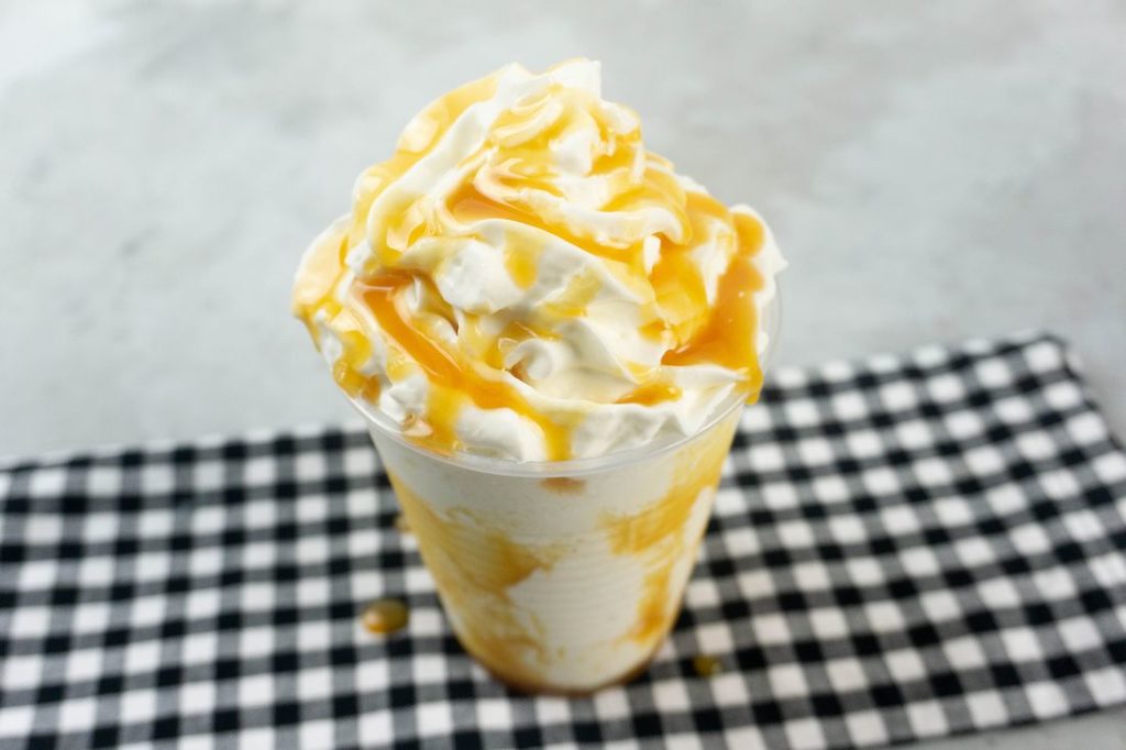 Butterbeer Frappuccino on a gray plaid napkin on a concrete backdrop