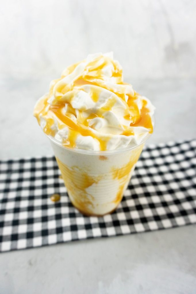 Butterbeer Frappuccino on a gray plaid napkin on a concrete backdrop