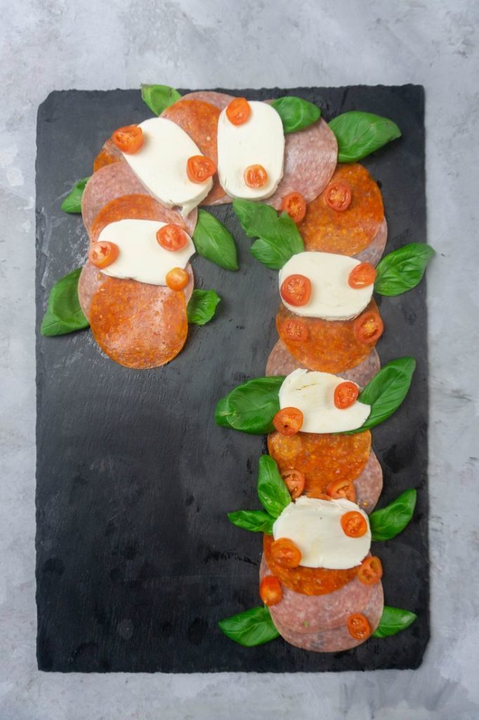 Charcuterie in the shape of a candy cane with salami and pepperoni
